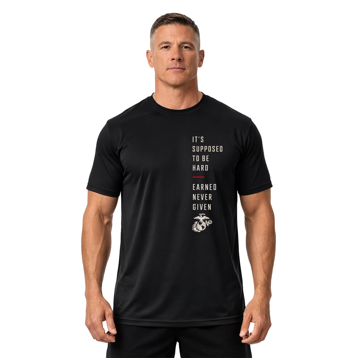 man wearing Black USMC It’s Supposed to Be Hard – Earned Never Given performance T-shirt with vertical chest graphic, red accent line, and Eagle, Globe and Anchor