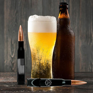 .50 Caliber Real Bullet Bottle Opener With The American Flag And Black Matte Casing Displayed with beer on table.